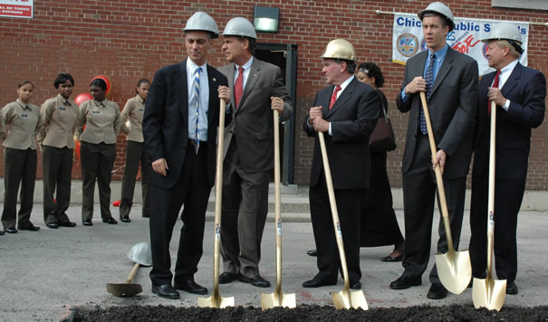 October 15, 2007. Chicago Mayor Richard M. Daley (center, in gold hard hat) joins (left to right) Congressman Rahm Emmanuel, Chicago Alderman Ed Balzer, CEO Arne Duncan, and retired Marine General Michael Mulqueen. Behind Daley (right) on the wall of the former elementary school is the banner of the Chicago Public Schools “Military Area Office” (which CPS claimed does not exist). To the left at ease are 9th grade students from the newly commissioned Marine Military Academy.  At the groundbreaking, Daley and Duncan announced an $8 million expansion of the “Grant Campus” (which now houses the Marine Academy and the Phoenix Military Academy, an Army program). The money for the expansion of the military campus at Adams and Western on Chicago’s West Side comes at a time when Daley and Duncan are telling public schools across Chicago that there is no money for capital improvements in the schools because the State of Illinois has refused to increase Chicago’s percentage of state education funding. Substance photo by George N. Schmidt.